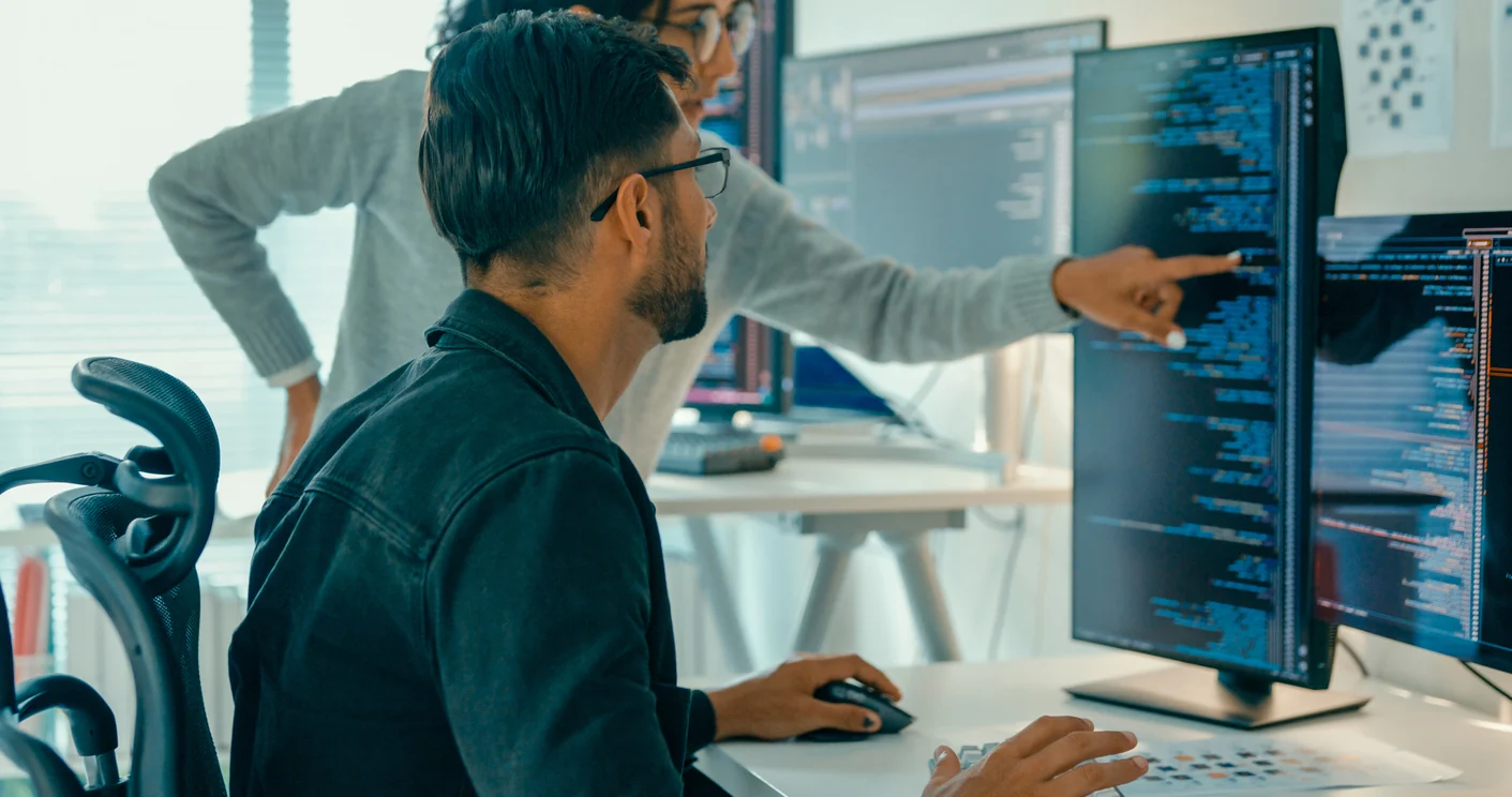 Two Opus Interactive engineers reviewing telemetry dashboards on screen.