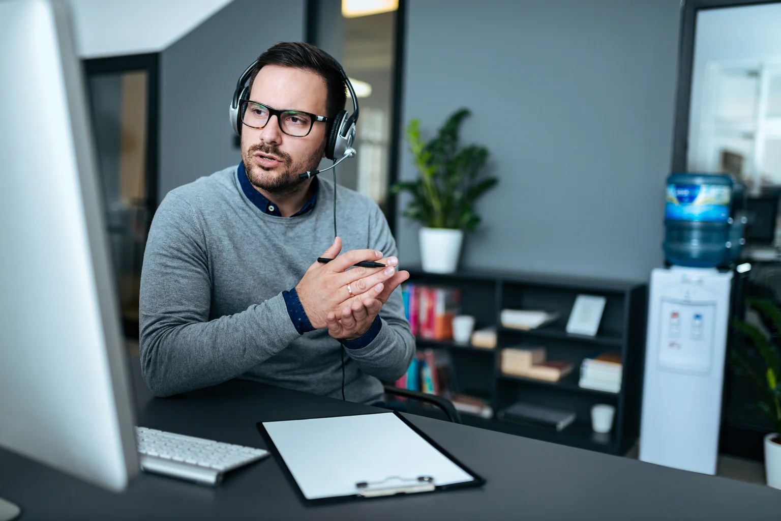 An Opus Interactive support engineer on a headset call at their desk.