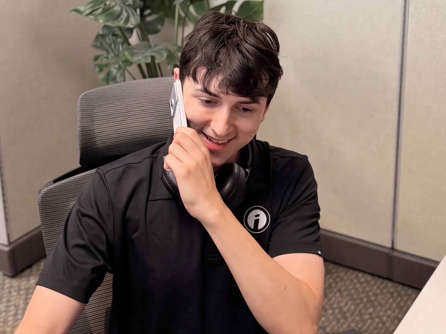 An Opus Interactive support engineer on the phone with a customer at their desk